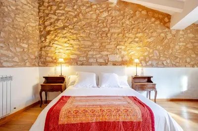 a bedroom with a large bed and two tables at Masía La Torre Historia Encanto y Naturaleza a Solo 10 Minutos de Sitges Gran comodidad, Vista a los Viñedos en un pueblo autentico in Viladellops