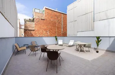 a patio with tables and chairs on a building at Stay U-nique Apartments Font BCN in Hospitalet de Llobregat