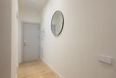 a hallway with a mirror on the wall and a door at Stay U-nique Apartments Font BCN in Hospitalet de Llobregat