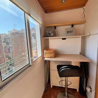 a desk and a chair in a room with a window at FlexCo City - Barcelona Flats in Barcelona