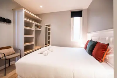 a bedroom with a large white bed and a chair at E2MAL1052 - Fantastic apartment next to Sagrada Fa in Barcelona