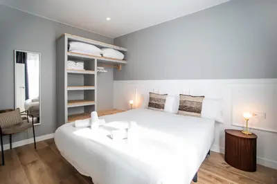 a bedroom with a large white bed and a chair at E2MAL1052 - Fantastic apartment next to Sagrada Fa in Barcelona