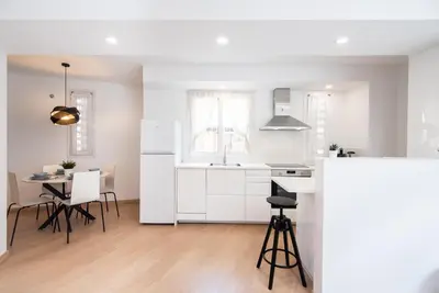 a kitchen with white cabinets and a table and chairs at Casa Jasmine Family Villa near the beach in Barcelona