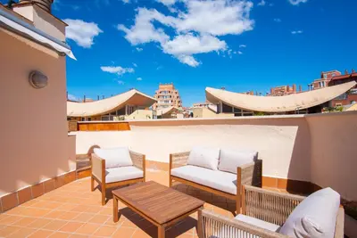 a patio with two chairs and a table on a balcony at Casa Jasmine Family Villa near the beach in Barcelona