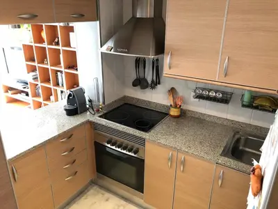 a kitchen with wooden cabinets and a stove top oven at Loft en Arenys de Mar in Arenys de Mar