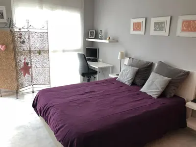 a bedroom with a large purple bed with a desk at Loft en Arenys de Mar in Arenys de Mar