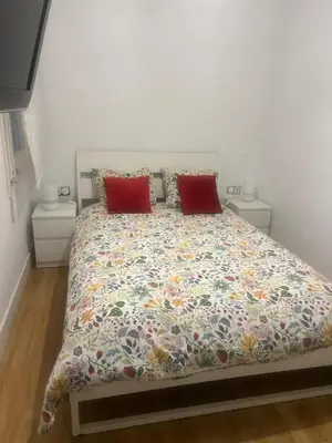 a white couch with two pillows on a bed at Apartamento cerca Playa in Sitges