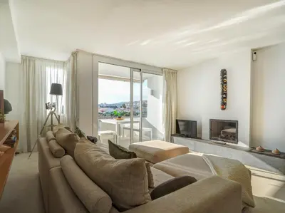 a living room with a large couch and a tv at Sunset apartment by Hello Homes Sitges in Sitges