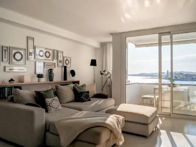 a living room with a couch and a large window at Sunset apartment by Hello Homes Sitges in Sitges