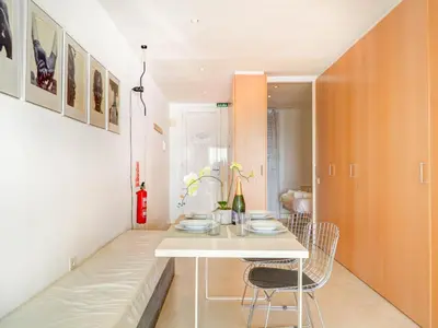 a dining room with a white table and chairs at Sunset apartment by Hello Homes Sitges in Sitges
