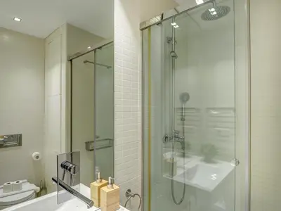 a bathroom with a glass shower and a sink at Sunset apartment by Hello Homes Sitges in Sitges