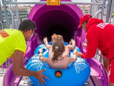 a group of people riding on an inner tube in a water slide at Golden Taurus Aquapark Resort in Pineda de Mar