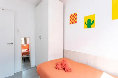 a bedroom with a bed with an orange blanket at Key Barcelona Diagonal Mar in Barcelona