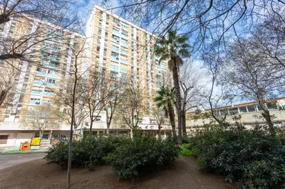 a tall building with a palm tree in front of it at Key Barcelona Diagonal Mar in Barcelona