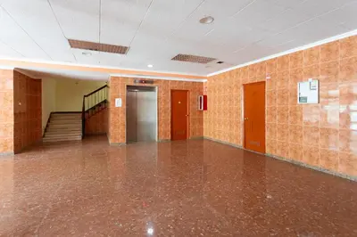 an empty room with a tile floor and stairs at Key Barcelona Diagonal Mar in Barcelona