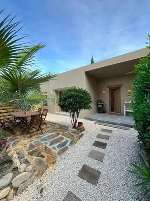 a patio with a table and a bench and a house at Stylish & idyllic Finca with private garden 5 min walking from South Beach Barcelona in Gava Mar in Barcelona