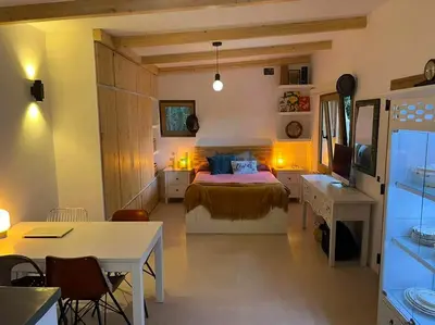 a bedroom with a bed and a desk and a tv at Stylish & idyllic Finca with private garden 5 min walking from South Beach Barcelona in Gava Mar in Barcelona