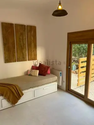 a bedroom with a bed and a door to a patio at Stylish & idyllic Finca with private garden 5 min walking from South Beach Barcelona in Gava Mar in Barcelona