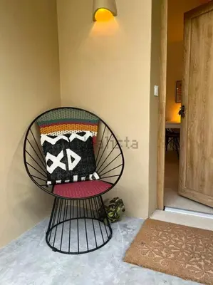 a chair with pillows on it in a room at Stylish & idyllic Finca with private garden 5 min walking from South Beach Barcelona in Gava Mar in Barcelona