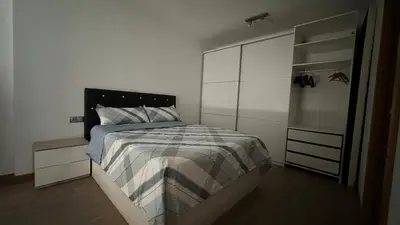 a white bedroom with a bed and a closet at Apt compartido martirrena in Badalona