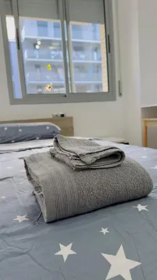 a blanket on a bed with stars on it at Apt compartido martirrena in Badalona
