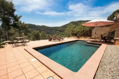 a swimming pool with a table and an umbrella at Nature & Tranquility only 25km from Barcelona in Torrelles de Llobregat