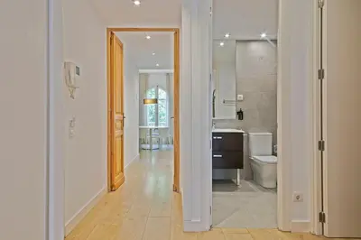 a white bathroom with a toilet and a sink at Ola Living Viladomat in Barcelona