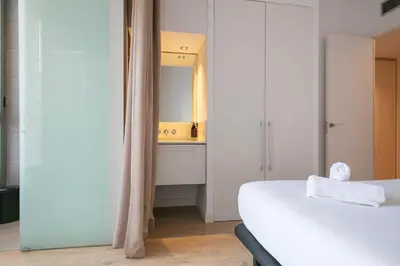 a bedroom with a white bed and a mirror at Ola Living Viladomat in Barcelona