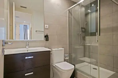 a bathroom with a toilet and a sink and a shower at Ola Living Viladomat in Barcelona
