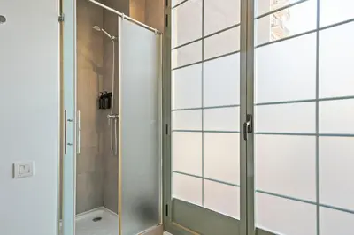 a shower with a glass door in a bathroom at Ola Living Viladomat in Barcelona