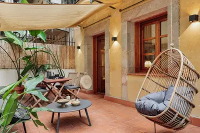 a patio with a swing chair and some plants at Komodo - 3 bedrooms and terrace in El Born in Barcelona