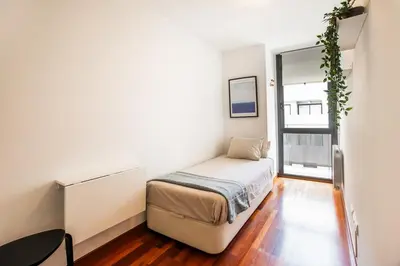 a small bedroom with a bed and a window at Mai&Maud Fira Apartment in Hospitalet de Llobregat