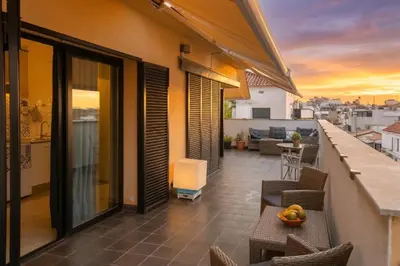 a room with black curtains and a chair and a mirror at Sunset Penthouse in Sitges
