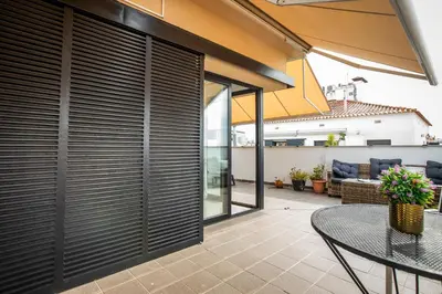 a balcony with a table and chairs on a building at Sunset Penthouse in Sitges