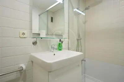 a white bathroom with a sink and a shower at Acogedor apartamento en Barcelona in Barcelona