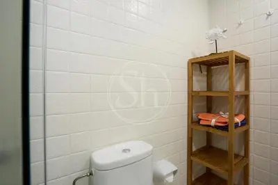 a bathroom with a toilet and a wooden shelf at Acogedor apartamento en Barcelona in Barcelona