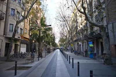 an empty city street with trees and benches and buildings at CITY CENTER TWO BEDROOMS APARTMENT, IN A 1870's FULL RENEWED BUILDING in Barcelona