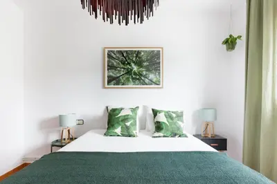 a bedroom with a bed with a green blanket at Casa Feliz del Mar in San Pol de Mar