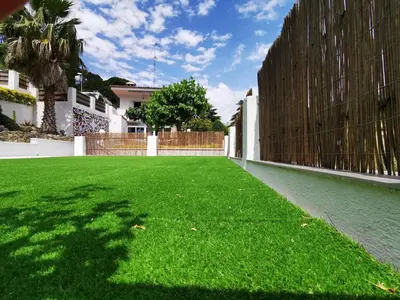 a large yard with green grass and a fence at Casa Feliz del Mar in San Pol de Mar