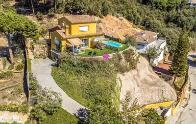 an aerial view of a yellow house on a hill at Stunning Home In Arenys De Munt in Arenys de Munt