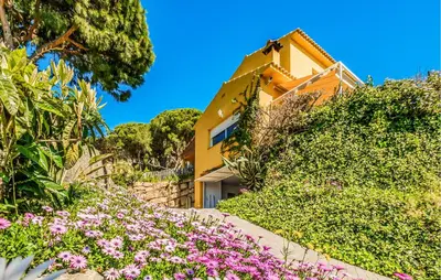 a yellow house with flowers in front of it at Stunning Home In Arenys De Munt in Arenys de Munt