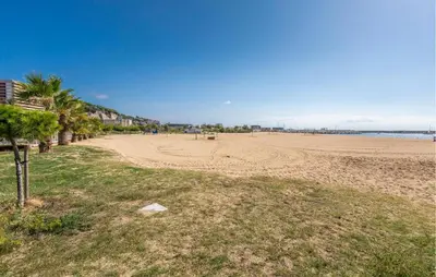 a sandy beach with palm trees and the ocean at Stunning Home In Arenys De Munt in Arenys de Munt
