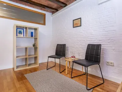 two chairs and a table in a room with a white brick wall at Apartment Icaria by Interhome in Barcelona