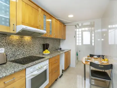 a kitchen with wooden cabinets and a wooden table at Apartment Icaria by Interhome in Barcelona