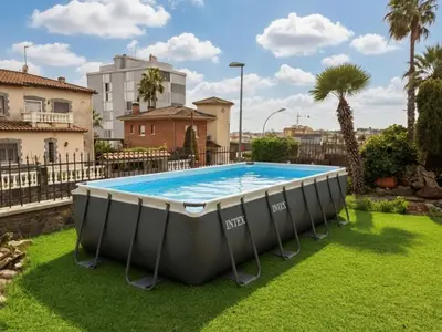 a large pool in a yard with grass and buildings at Holiday Home Bon repos by Interhome in Cunit
