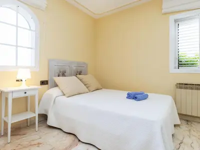 a bedroom with two beds and a table and window at Holiday Home Bon repos by Interhome in Cunit
