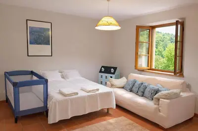 a living room with a couch and a bed and a window at Masia Can Cenç in Collsuspina