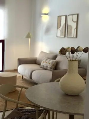 a living room with a table and a vase with flowers at Boutique Temporada VG Barcelona Sant Gervasi in Barcelona