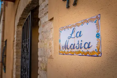 a sign on the side of a building at La Masia in Sant Pau dʼOrdal