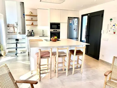 a kitchen with a large island with chairs around it at Mi casa soñada in Sant Pere de Ribes